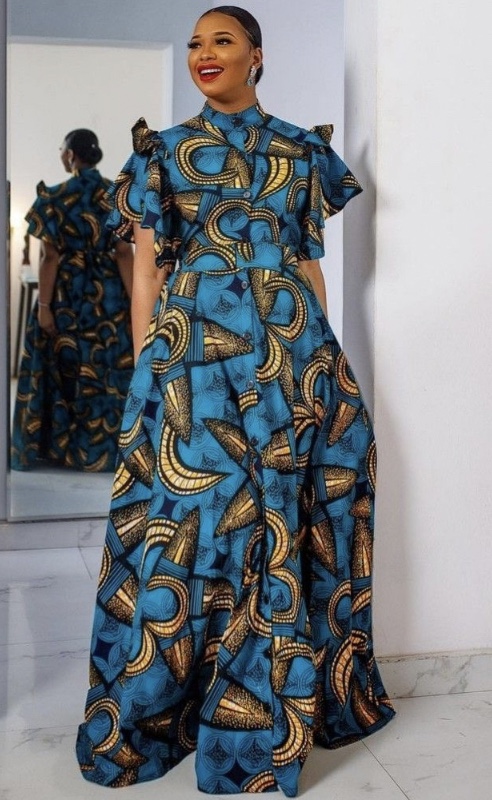 Smiling woman wearing a vibrant African print dress, looking at the camera